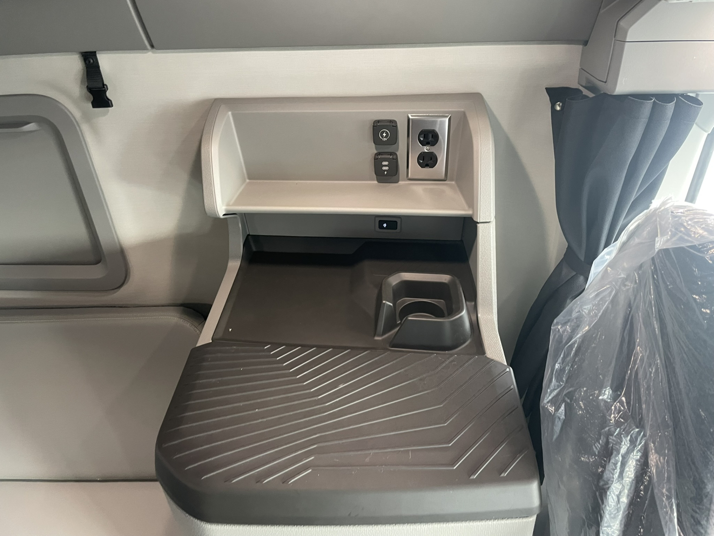 Volvo VNL64T860 sleeper cab interior with control panel, cup holder, and power outlets visible in the upper bunk area.