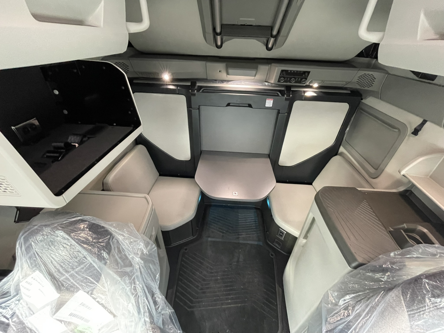 Volvo VNL64T860 interior view of the sleeper cab with seating area and storage compartments visible.