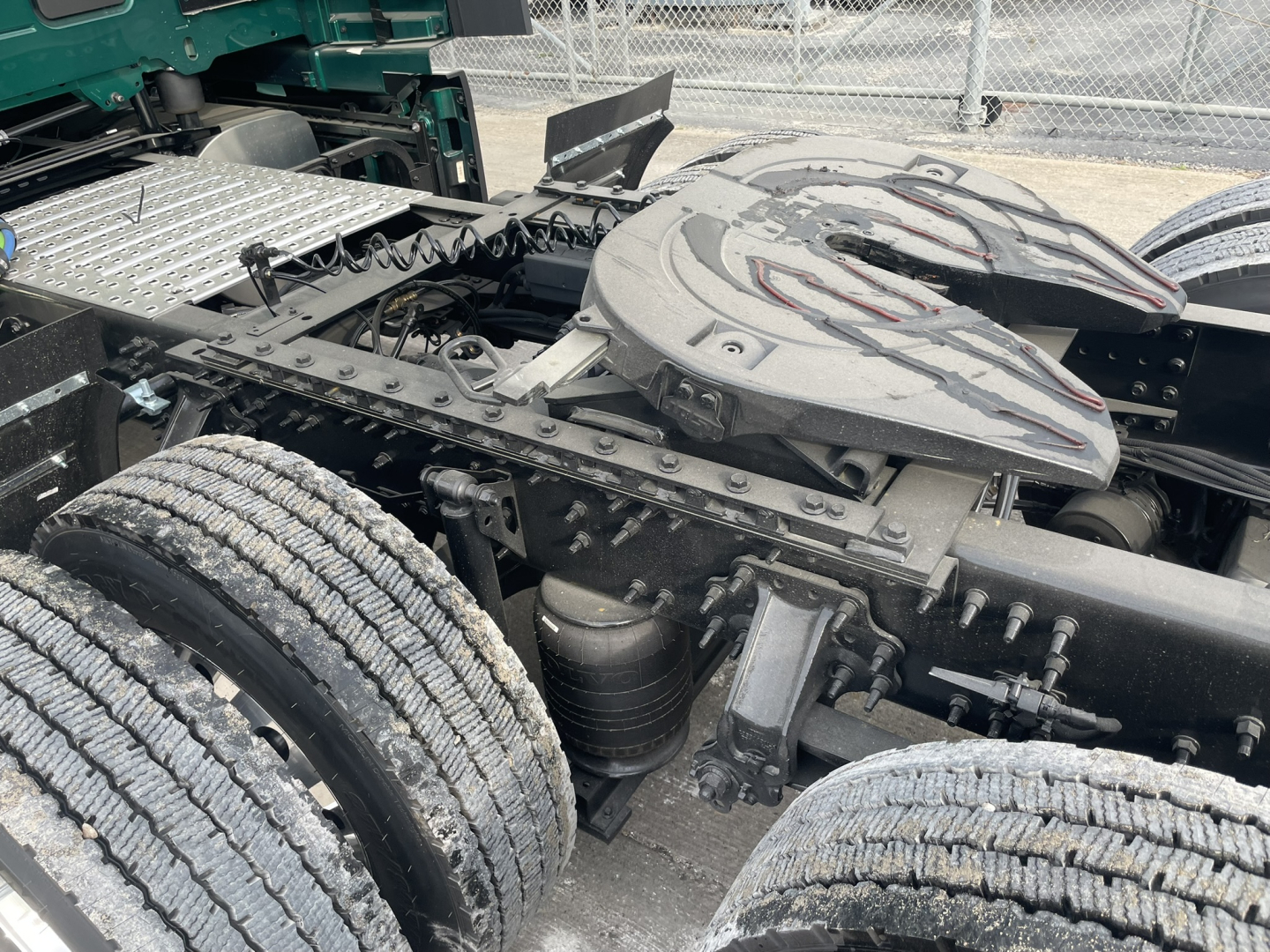 Volvo VNL tractor tandem rear showing fifth wheel and chassis components with dual rear axles and air/electrical lines.