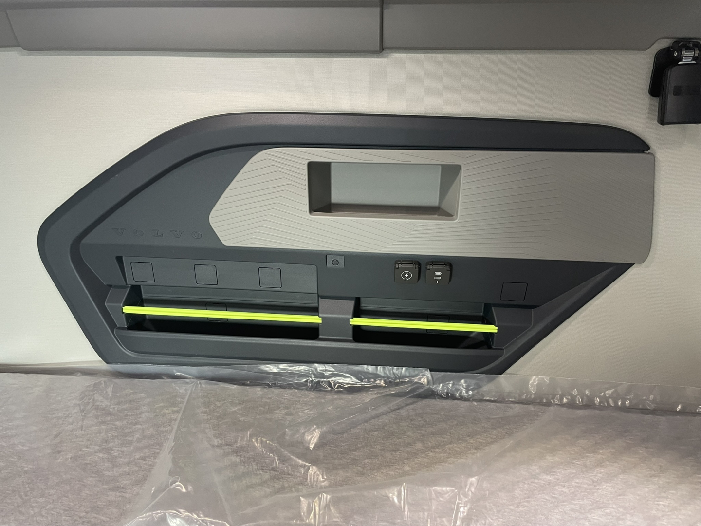Volvo VNL64T860 sleeper cab interior showing under-bunk storage cabinet with two yellow-labeled latches.