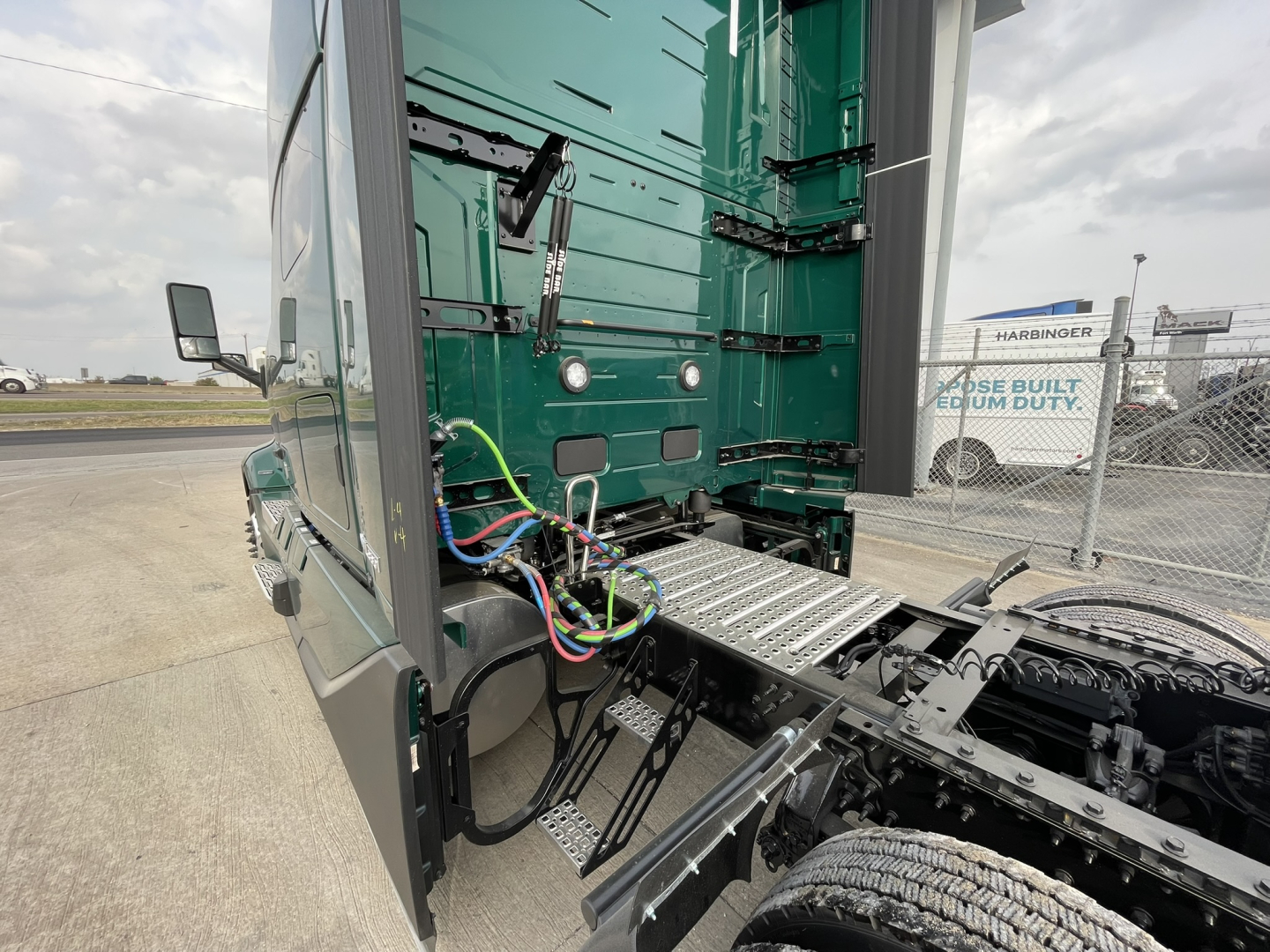 Volvo VNL64T860 truck cab with exposed wiring, steps, and chassis in view.
