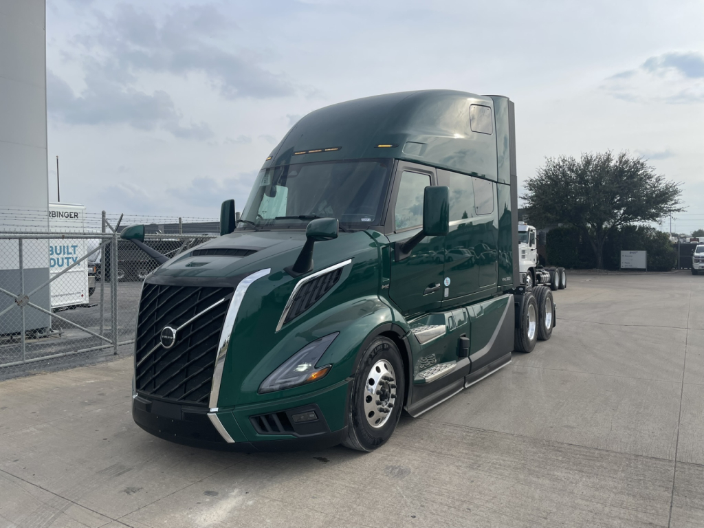 Volvo VNL64T860 truck cab in view showing exterior with green color, sleeper cab, front grille, headlights, and chrome accents.
