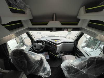  Volvo VNL64T860 truck cab interior view with steering wheel dashboard and seats wrapped in plastic.