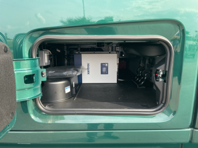 Volvo VNL64T860 engine bay storage compartment showing auxiliary power unit and equipment in rear cabinet.