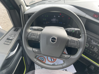 Volvo steering wheel and dashboard inside a new 2026 Volvo VNL64T860 truck showing steering wheel controls and digital instrument cluster.