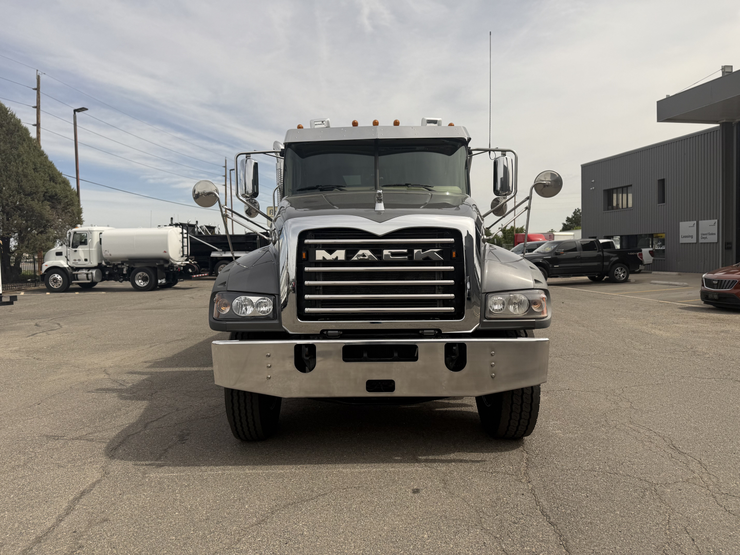 Front view of a Mack GR64F dump truck showing large grille with MACK lettering and chrome bumper.