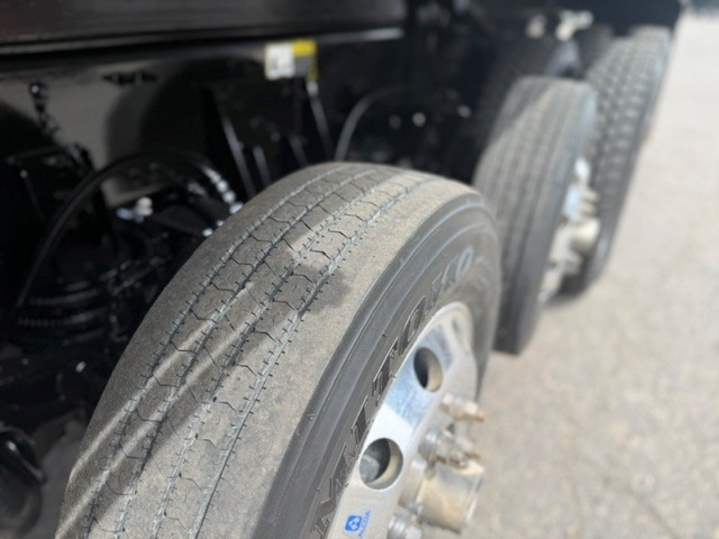 Wheel and tire of a 2024 Mack GR64F dump truck showing tread pattern and dual rear tire setup.