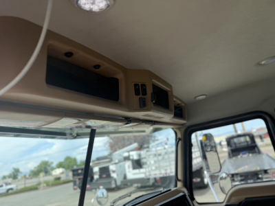 Cab interior of a Mack GR64F showing overhead console with controls, vents, and storage panel.