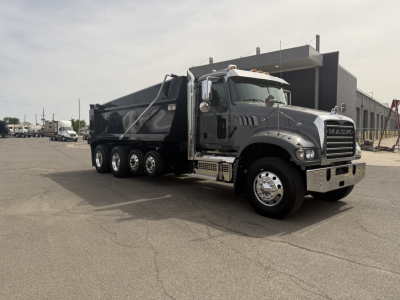 Mack GR64F dump truck in-service showing side view with black dump bed and chrome bumper.