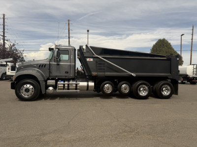 Mack GR64F dump truck side view showing dump bed and multiple axles.