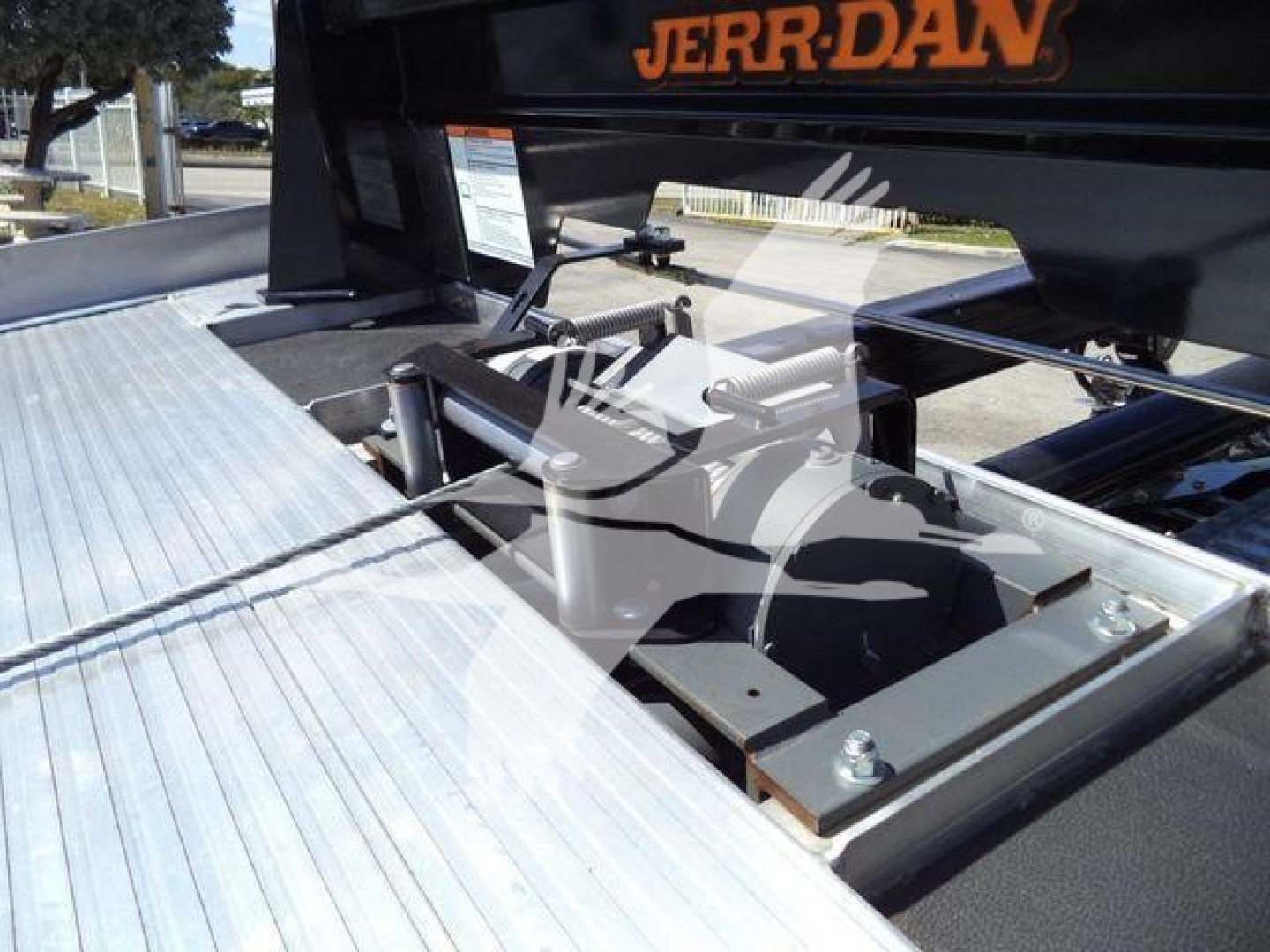 Truck bed hitching mechanism and metallic platform shown in a Ram 5500 rollback setup with Jerr-Dan branding.