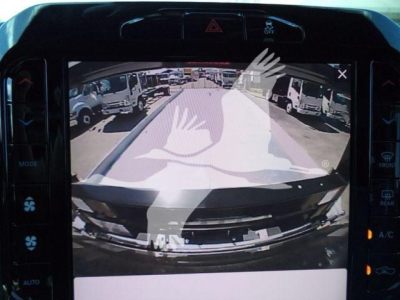 Trucks listing image showing Ram 5500 dashboard display with backup camera view of a rollback truck lot from a vehicle’s reverse camera.