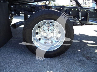 Wheel and tire of a Ram 5500 rollback truck visible with chrome hubcap and Hankook tire. Partial undercarriage with frame and suspension components.