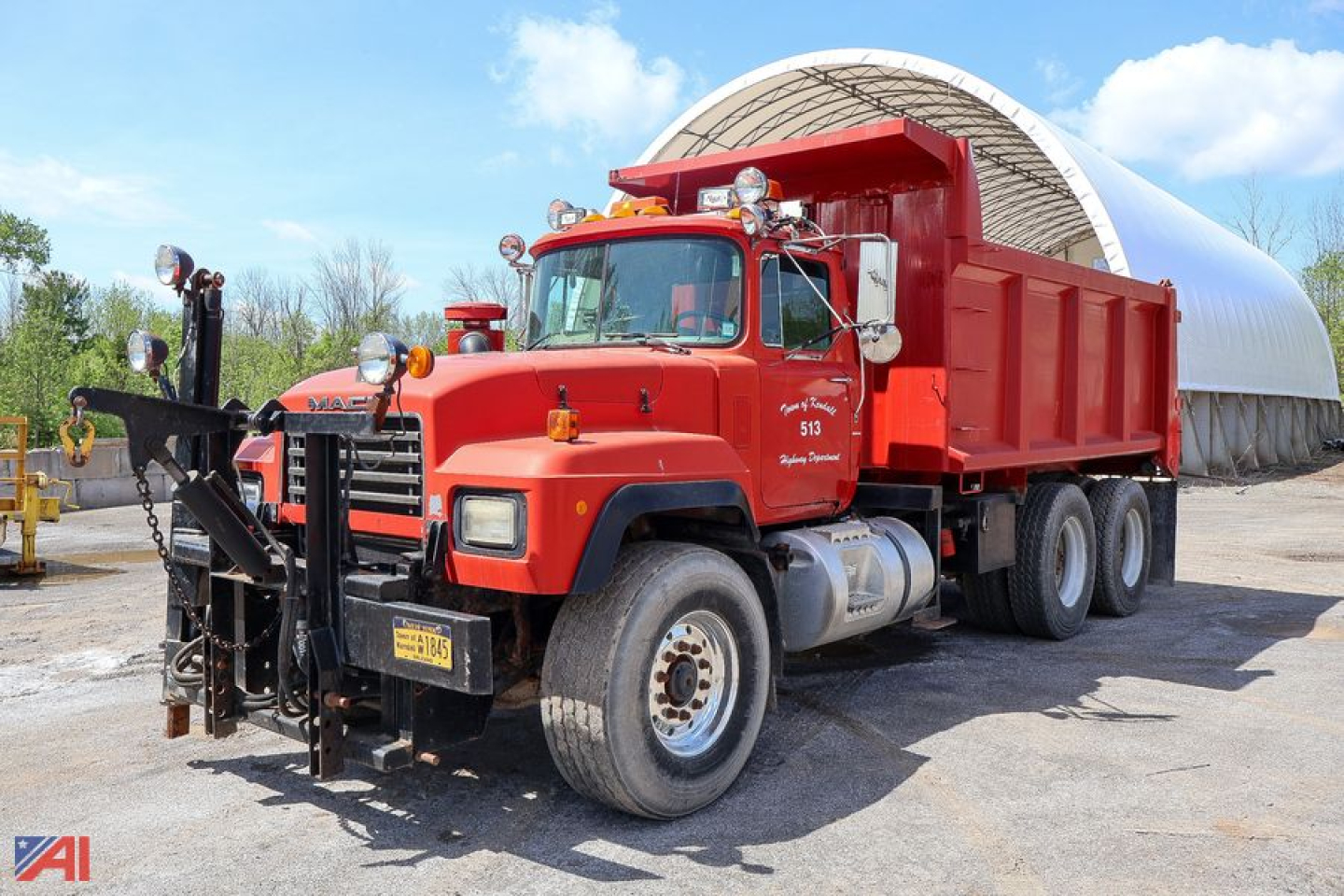 Dump truck showing RD690S Mack dump bed in red with front-mounted equipment and dual rear axles.