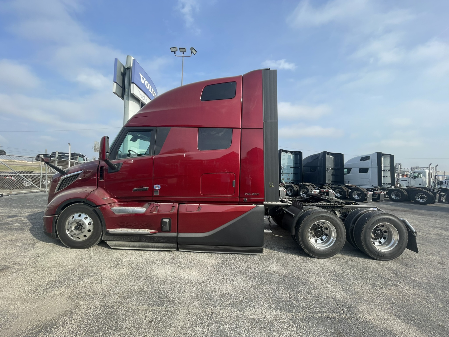 Volvo VNL64T860 tractor side view showing cab and chassis, red color, with sleeper cab and rear wheels. 