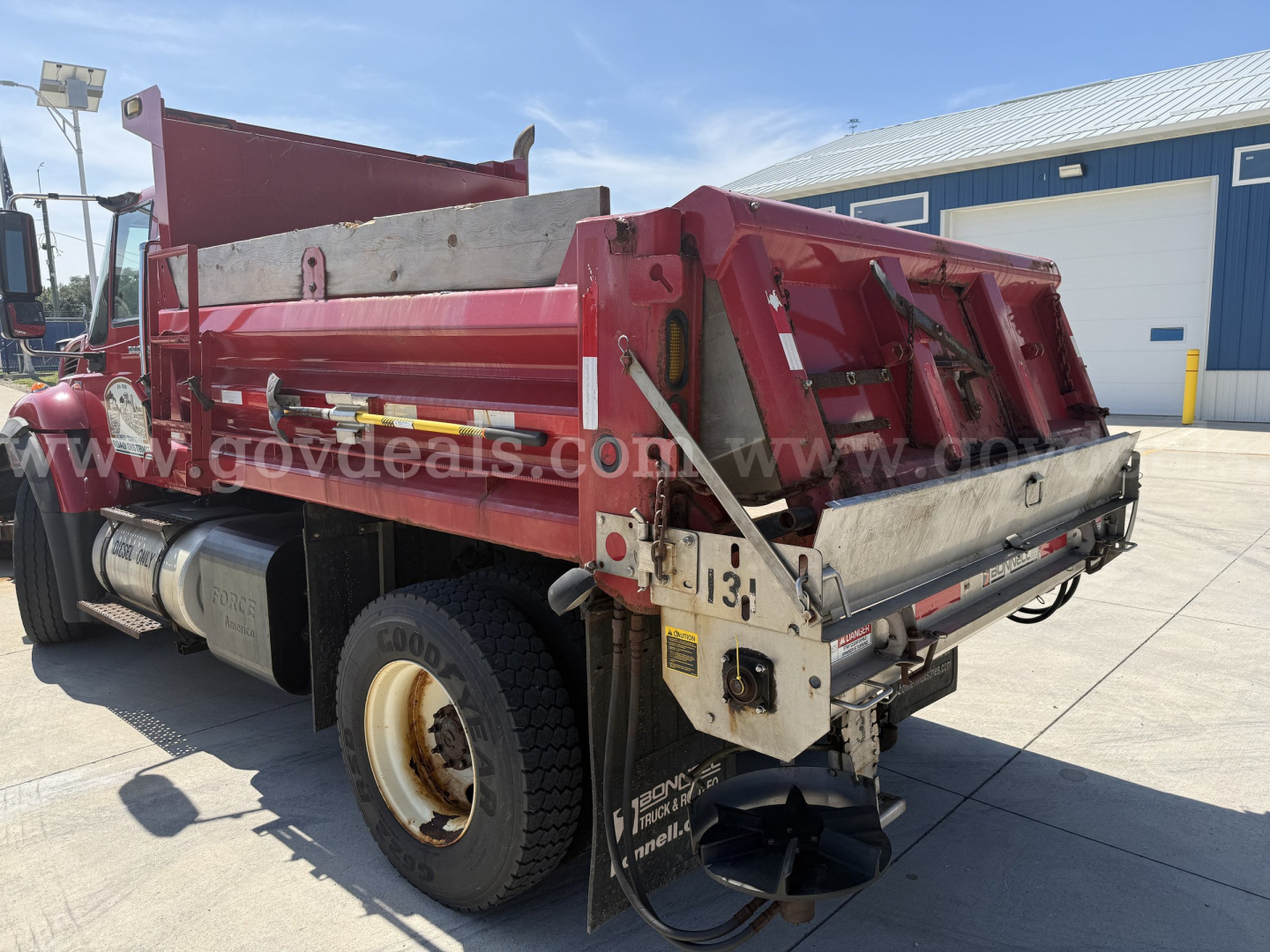 Truck dump bed rear view showing dump control and hydraulic components on 2012 International 7400 dump truck.