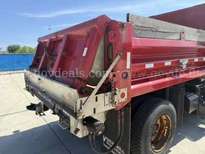 Dump truck bed of a 2012 International 7400 showing rear tailgate and hydraulic components.