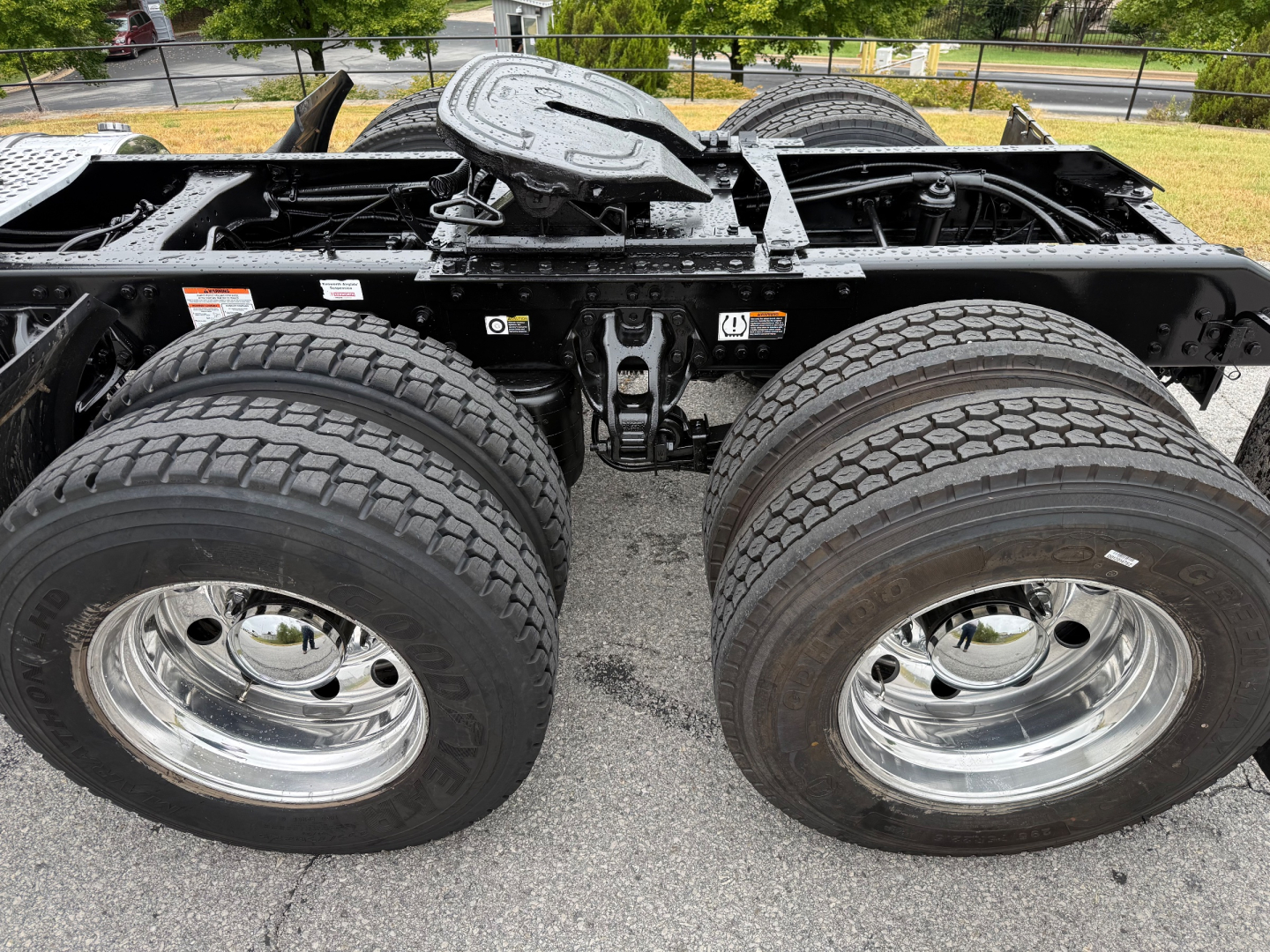 Kenworth T880 chassis showing dual rear axles with large tires and chrome wheels, undercarriage frame and fifth wheel visible, fuel/tank area and suspension components.