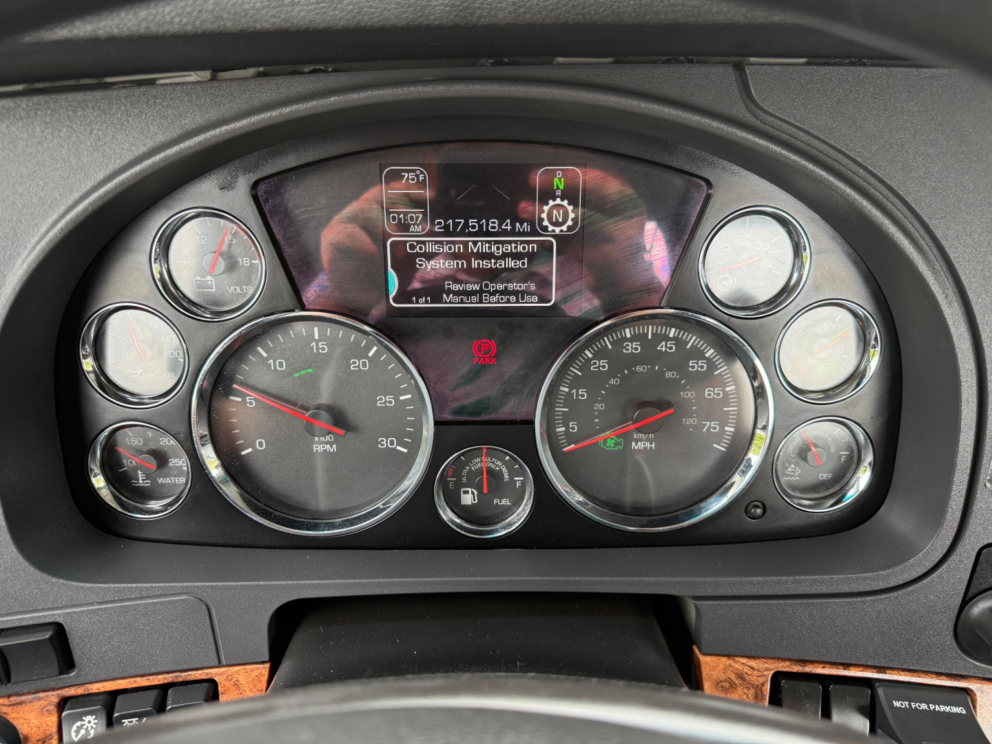 Kenworth T880 dash cluster showing gauge meters and central display; visible text includes vehicle information and diagnostic prompts.