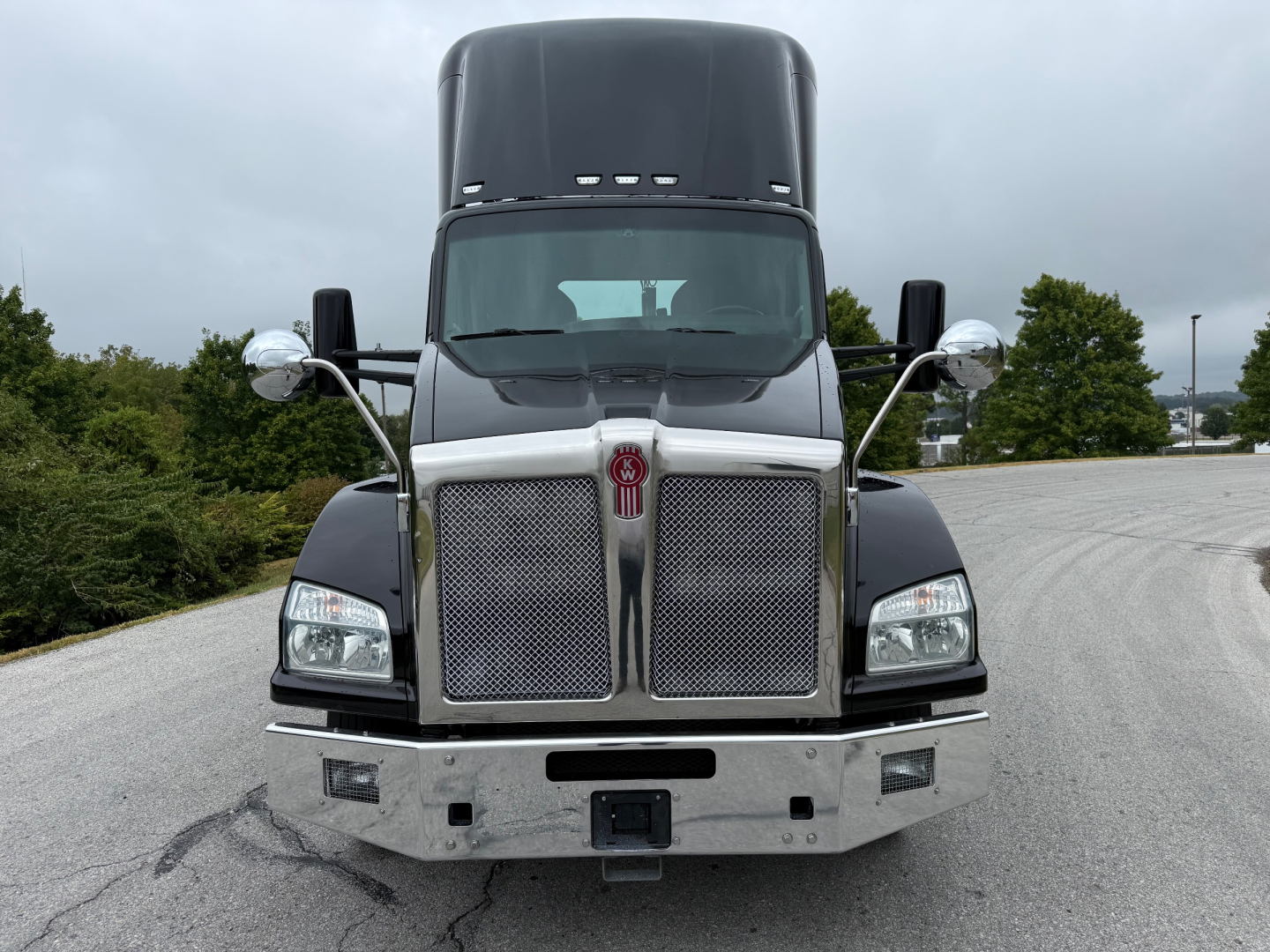 Kenworth T880 conventional daycab truck front view showing grille, bumper, dual side mirrors and badge. VIN/stock not visible.