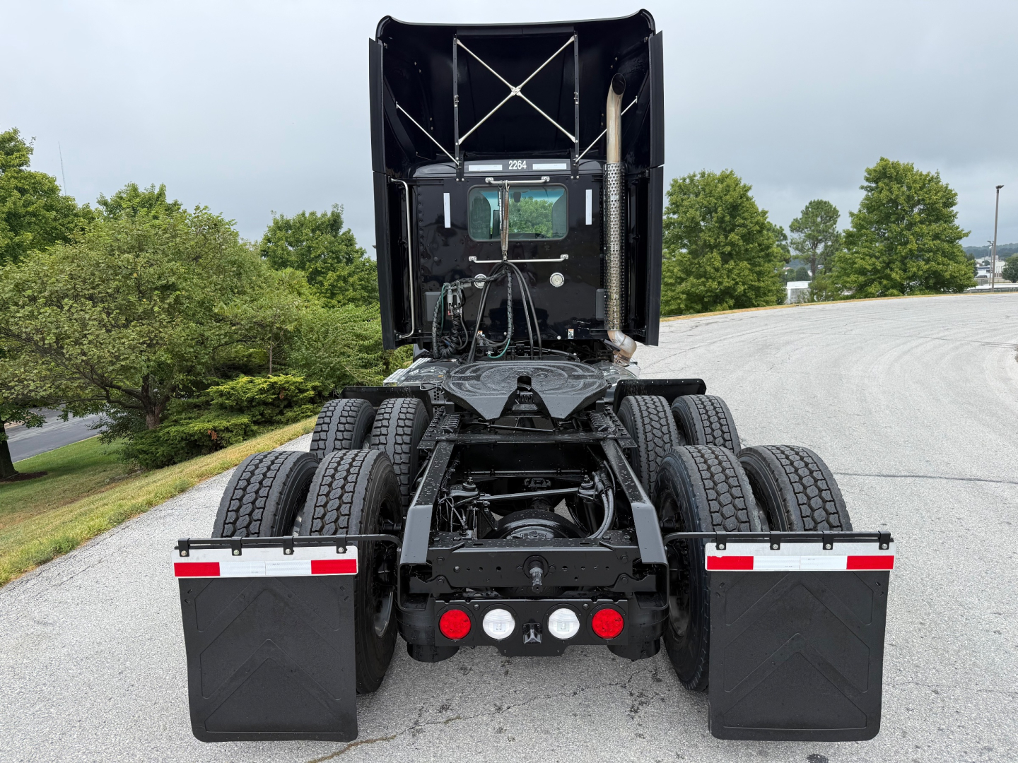 Kenworth T880 rear view showing fifth wheel, dual rear axles, mud flaps, and rear lights with stock number plate; chassis and cab visible.
