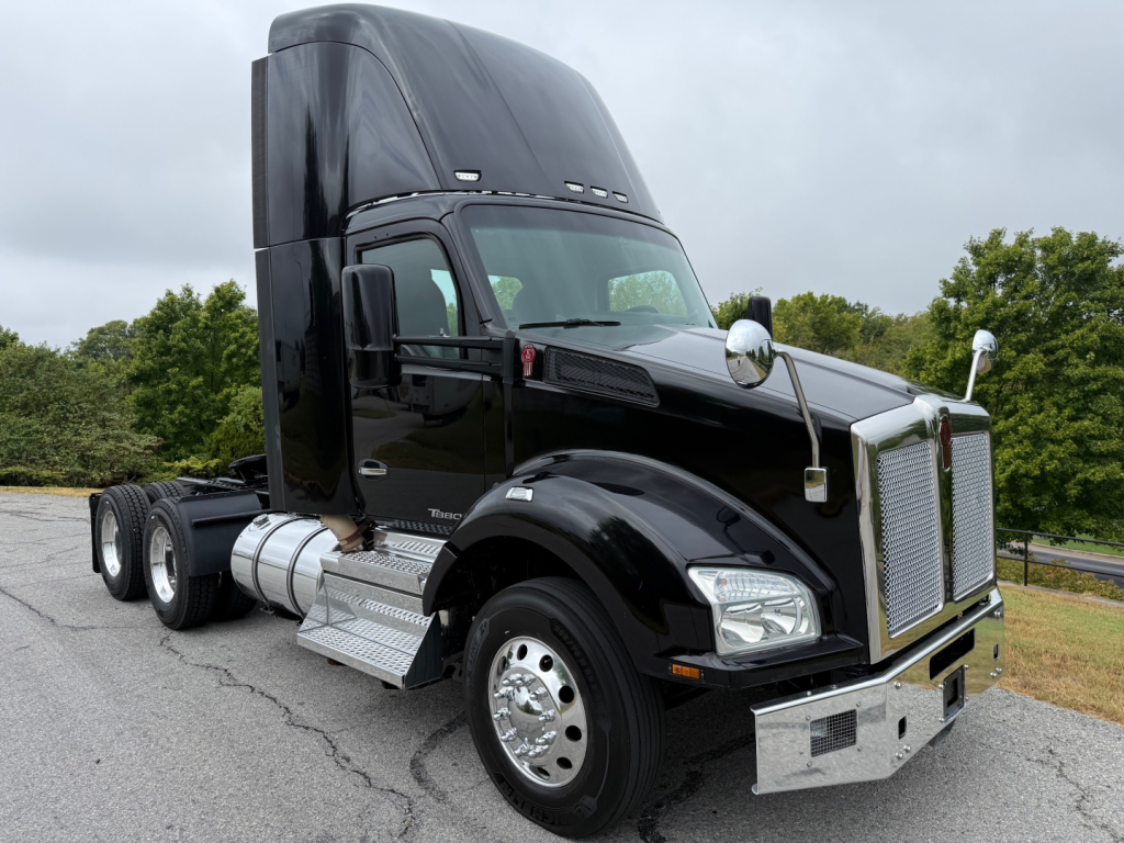 Kenworth T880 truck cab and chassis side view with black paint and chrome accents, large sleeper cab, dual rear axles, chrome fuel tanks, and front grille.