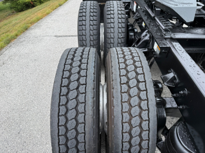 Kenworth T880 chassis showing dual rear axles with treaded tires and drivetrain components.