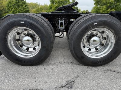 Kenworth T880 truck axle with dual rear wheels (dually) showing chrome rims and suspension components.