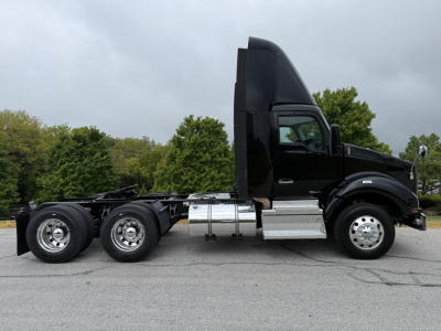 Kenworth T880 tractor-trailer side profile showing cab and chassis with dual rear axles, black paint, chrome fuel tanks and steps.
