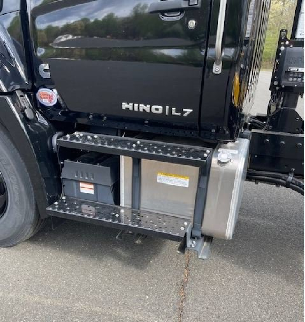 Cab chassis truck showing HINO L7 badge on door with side step and fuel/tank compartments.