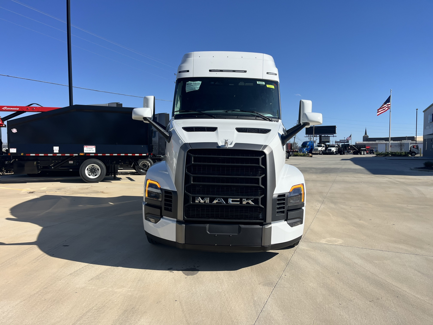 Mack PR64T76M truck front view showing grille and headlights in a dealership lot.