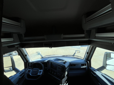Cab interior of a 2026 Mack PR64T76M showing dash cluster and steering wheel from front cab perspective.
