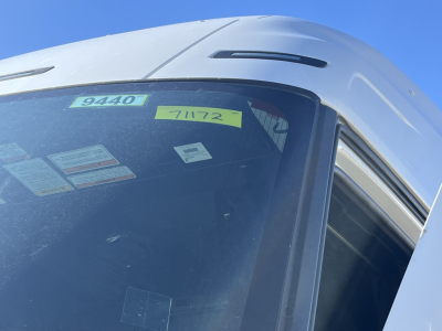 Truck cab window with stickers showing 9440 and 71172, part of a 2026 Mack PR64T76M conventional sleeper in a vehicle lot.