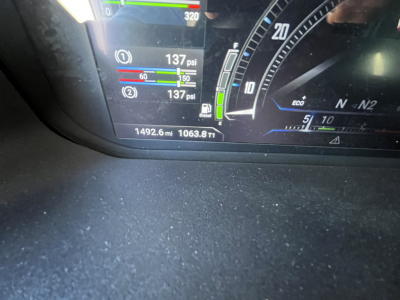 Vehicle dashboard showing gauge cluster with psi readings, 1492.6 miles, 1063.8 hours/ta, and various meters; digital display with green and blue bars.