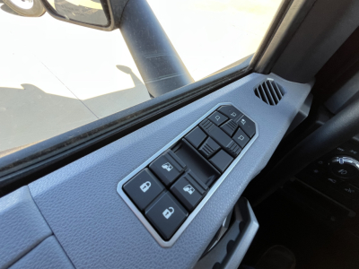 Truck interior door panel with window and lock controls; window switches and mirror adjustment seen in Mack PR64T76M cab.