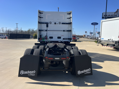 Truck chassis rear view showing fifth wheel area and dual rear axles on a new Mack PR64T76M tractor in a dealership lot.