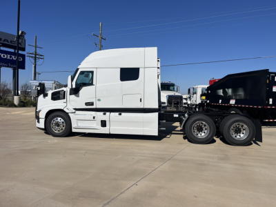 Truck tractor side view showing white Mack PR64T76M sleeper cab with raised roof and dual rear axles.
