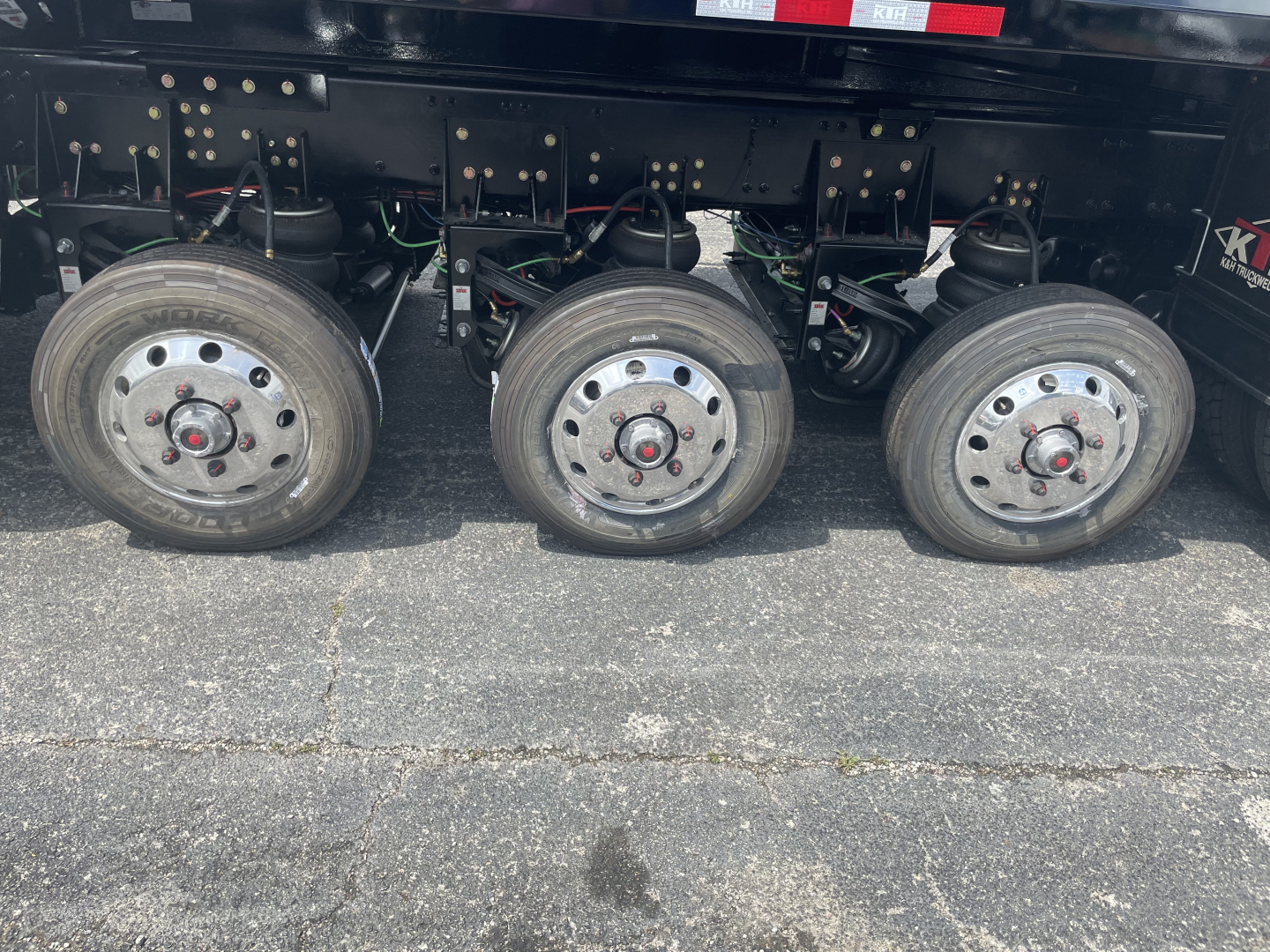 Volvo VHD64F300 dump truck undercarriage showing three drive wheels and suspension components