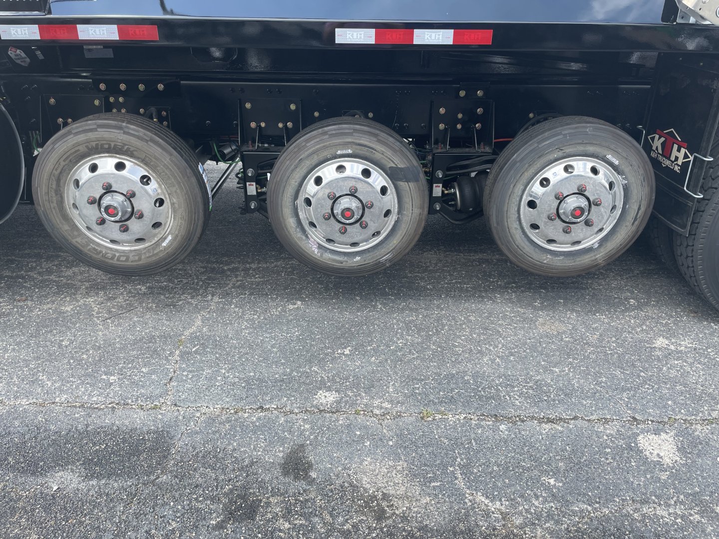 Volvo VHD64F300 dump truck side showing triple rear axles and steel wheels.