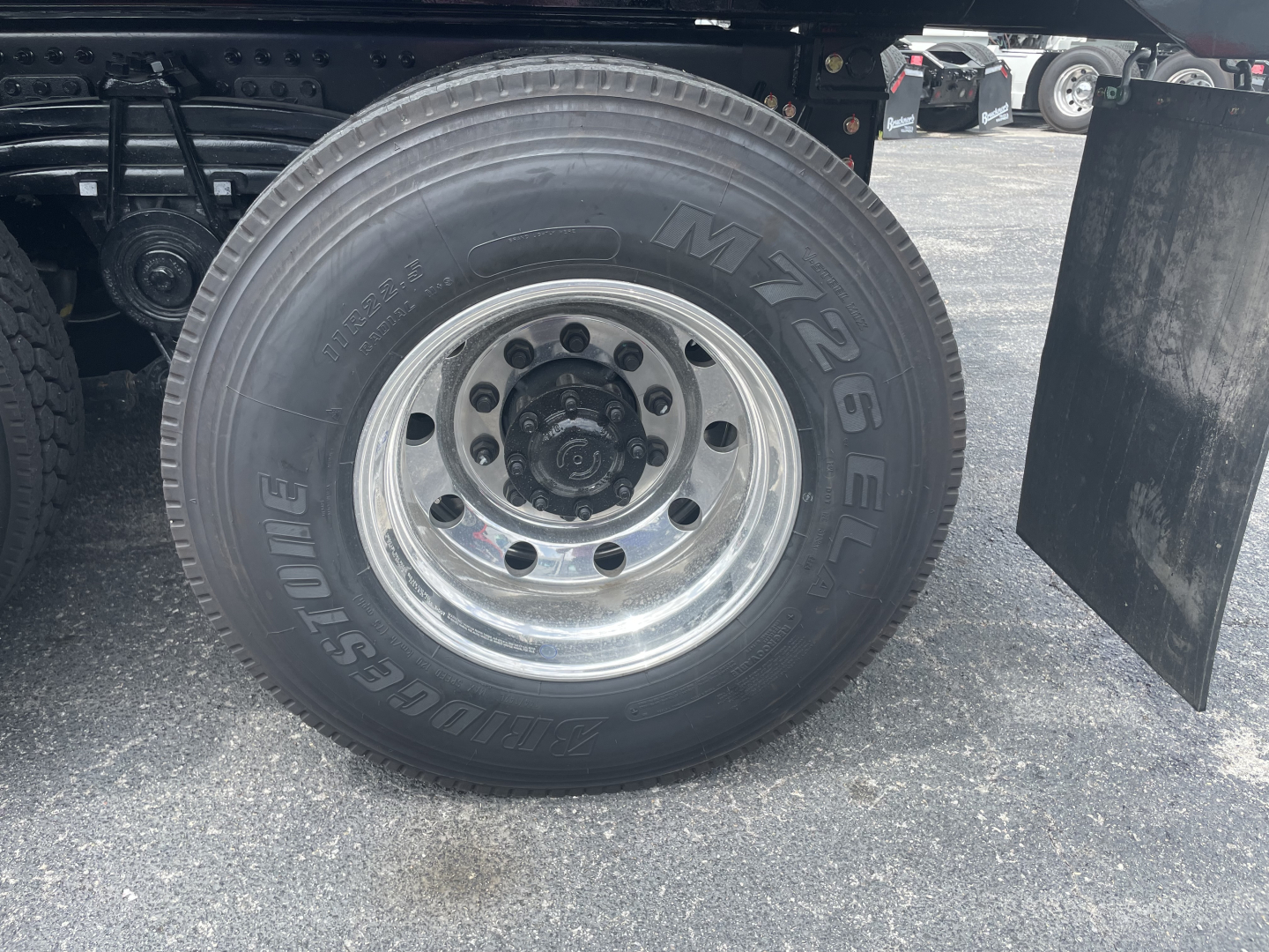 Volvo VHD64F300 truck wheel and tire showing M+S tire brand with steel rim and hub, under-carriage components visible.