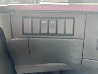 Truck cab interior showing auxiliary switch panel labeled AUX AUX with blank switch positions