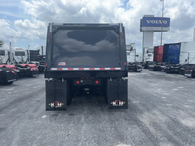 Volvo VHD64F300 dump truck rear showing dump bed, taillights, and mud flaps with KH logo.