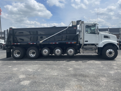Volvo VHD64F300 dump truck side profile showing large black dump body and chrome cab, 6x4 configuration, multiple rear axles.