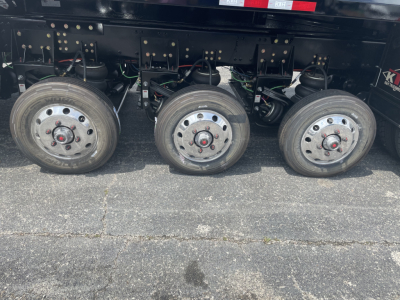 Volvo VHD64F300 dump truck undercarriage showing three drive wheels and suspension components