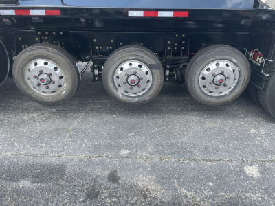 Volvo VHD64F300 dump truck side showing triple rear axles and steel wheels.