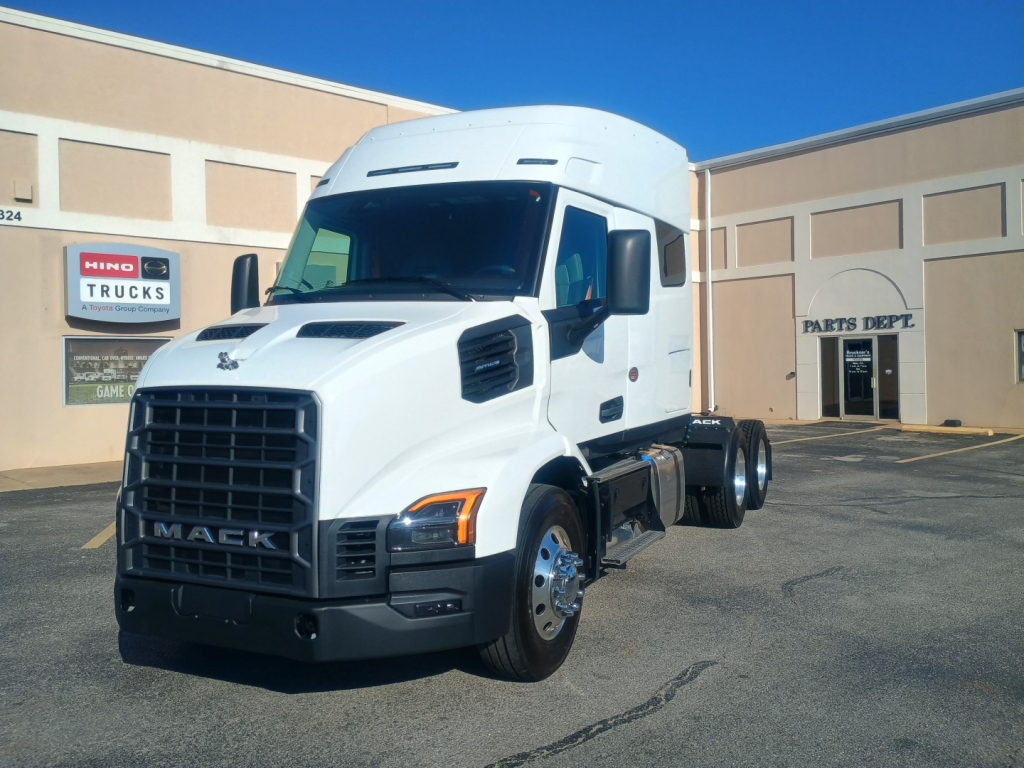 Mack AN64T64 conventional sleeper truck in a dealership lot, white cab, large grille, front view, stock number 72208.