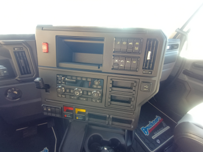 Dashboard of a Mack truck cab showing control panels, switches, and climate controls with a touchscreen slot and various labeled buttons.