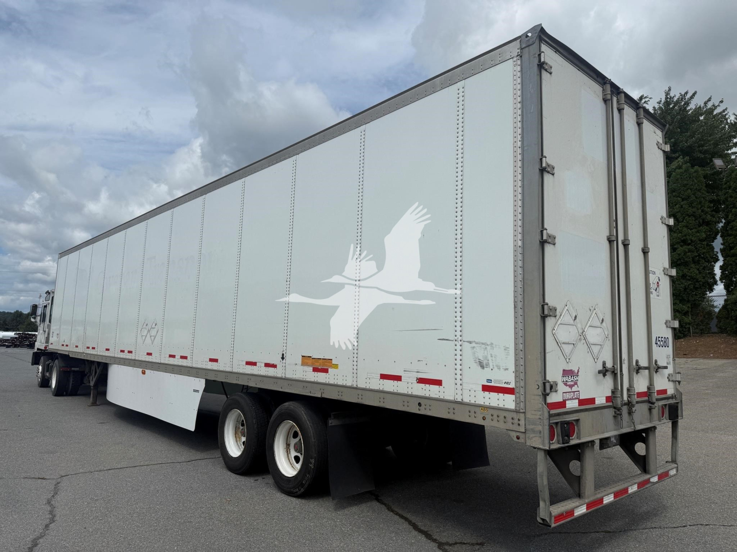 Trailer: 2017 Wabash dry van with side and rear doors, white with bird graphic, dual rear doors, running lights, and tandem axles.