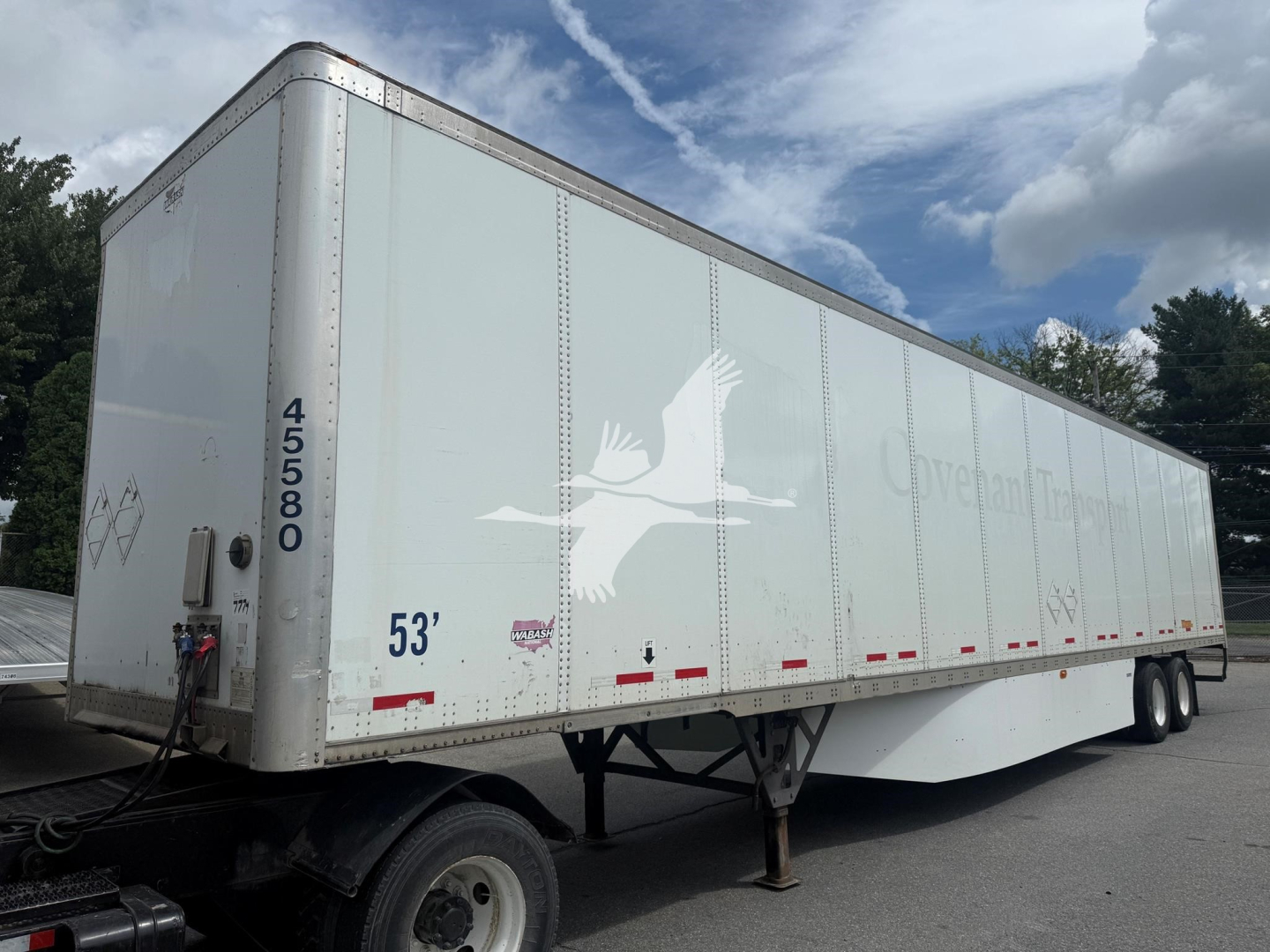 Trailer side profile showing a white 53' dry van with blue graphics and wheel tandem. Text includes 'VERSA...'? and numbers 45580? and 53' visible.