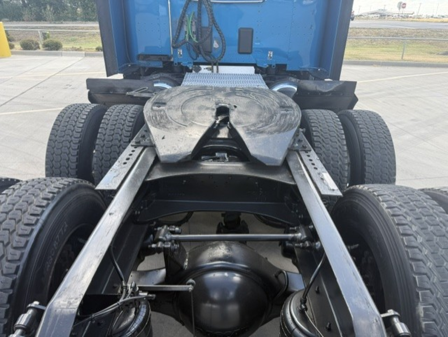 Peterbilt 579 chassis rear view showing fifth wheel, dual rear axles, and drivetrain components under the cab.